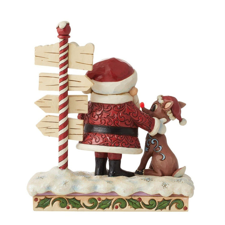Jim Shore Rudolph Traditions: Rudolph and Santa Next to Sign Figurine sparkle-castle