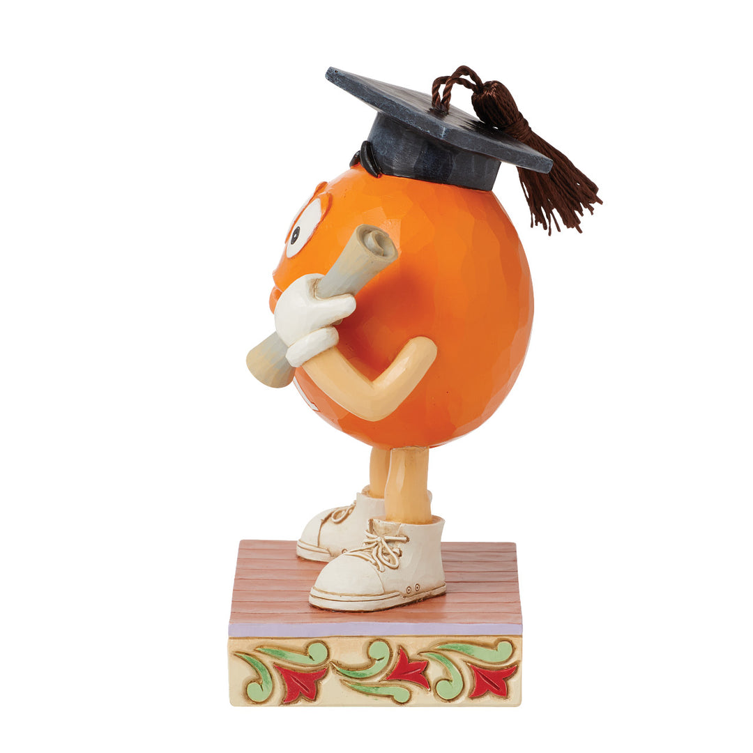 Jim Shore M&M'S: Orange M&M in Graduation Cap Figurine sparkle-castle