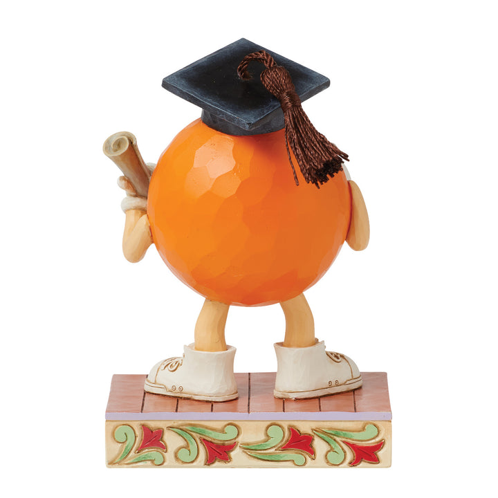 Jim Shore M&M'S: Orange M&M in Graduation Cap Figurine sparkle-castle