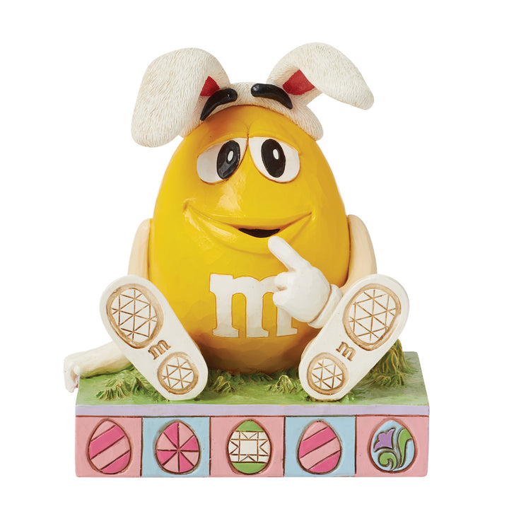 Jim Shore M&M'S: Yellow M&M Sitting With Easter Bunny Ears Figurine sparkle-castle