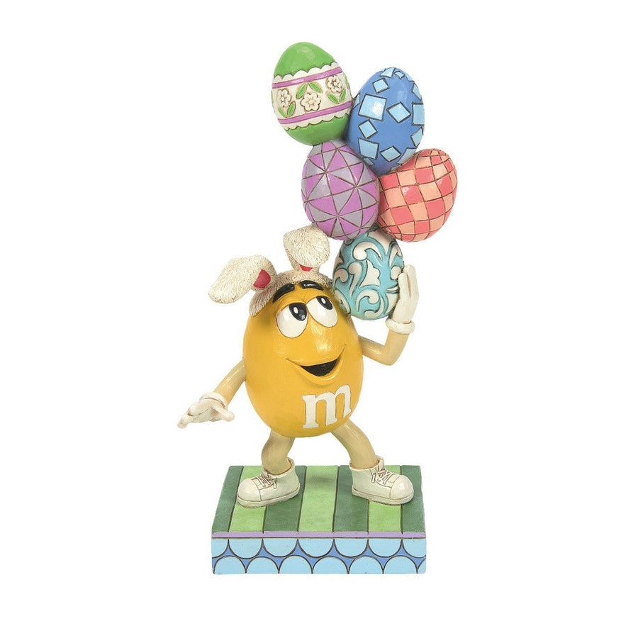 Jim Shore M&M'S: Yellow Easter M&M With Stacked Eggs Figurine sparkle-castle
