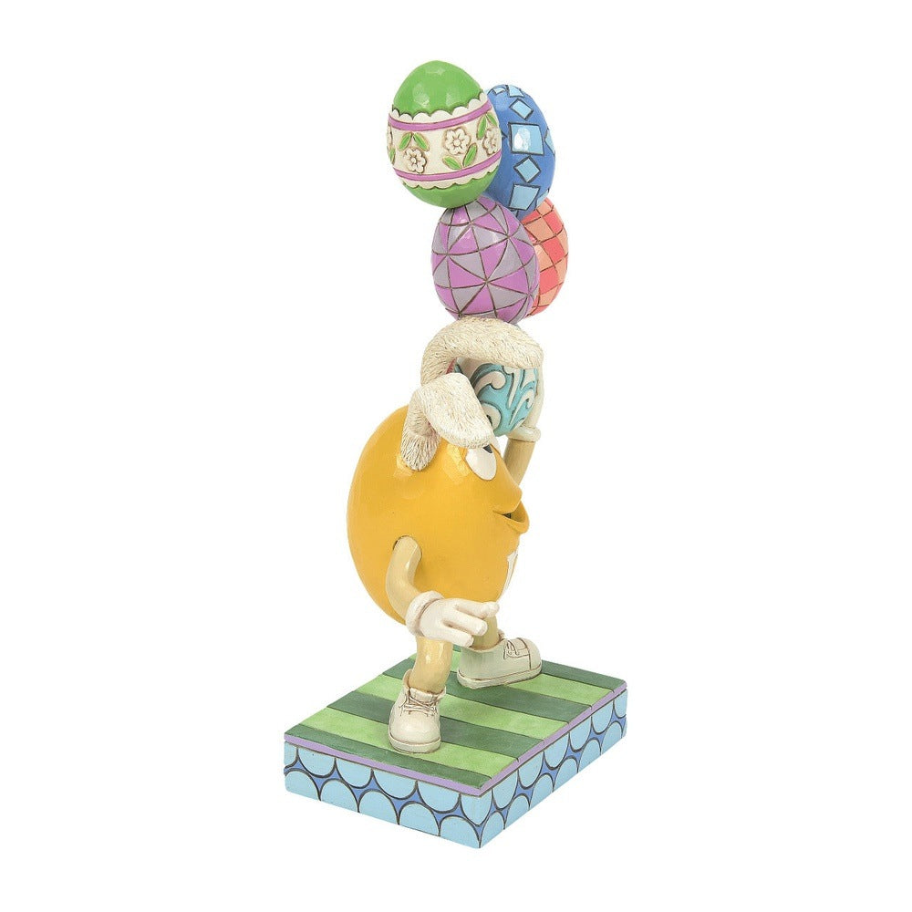 Jim Shore M&M'S: Yellow Easter M&M With Stacked Eggs Figurine sparkle-castle